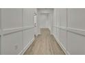 Bright hallway with wood-look flooring, crisp white trim, and modern wainscoting detail at 10383 Lear St, Spring Hill, FL 34608