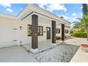 Inviting front porch with stylish pillars, a modern front door, and well-manicured landscaping at 1154 64Th S Ave, St Petersburg, FL 33705