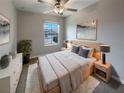 Cozy bedroom featuring a comfortable bed, stylish decor, ceiling fan, and a bright window view at 1526 Cassius St, Lutz, FL 33549