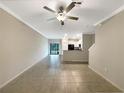 Spacious living room with tile flooring, ceiling fan, leading to an open-concept kitchen and backyard access at 1526 Cassius St, Lutz, FL 33549