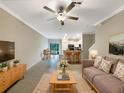 Inviting living room with modern furnishings, tile floors, a ceiling fan, and an open concept design at 1526 Cassius St, Lutz, FL 33549