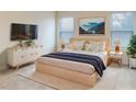 Bright bedroom featuring a sleek platform bed, stylish dresser with TV, and modern decor accents at 6310 116Th E Ave, Parrish, FL 34219