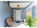 Welcoming front porch with bench seating, potted plants, and 'welcome' sign hanging on the door at 9628 Southern Charm Cir, Brooksville, FL 34613