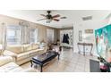 Comfortable living room with tile floors, large window, ceiling fan and access to the front entryway at 9628 Southern Charm Cir, Brooksville, FL 34613