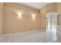 A spacious room with neutral walls, white tile flooring, and natural light from the front door at 7622 Hampshire Garden Pl, Apollo Beach, FL 33572