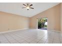 Bright room featuring tile floors, tan walls, ceiling fan, and sliding glass doors to the outside at 7622 Hampshire Garden Pl, Apollo Beach, FL 33572