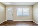 Neutral living room with new laminate floors, front door and large window at 1542 39 S St, St Petersburg, FL 33711