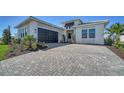 Paver driveway leads to a two-car garage and modern home exterior at 4541 Mondrian Ct, Sarasota, FL 34240