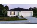 Charming single story home with lush lawn, a gray roof, and an attached two-car garage at 1317 Arrow St, Port Charlotte, FL 33952