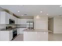 Well-lit kitchen features granite countertops, stainless steel appliances, and an island with sink at 1317 Arrow St, Port Charlotte, FL 33952