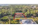 Aerial view of a home with boarded-up windows and a brown roof, surrounded by dense trees at 6098 San Salvador Rd, North Port, FL 34291