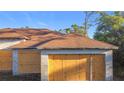 Close-up of the garage with boarded-up doors and cinder block construction, under a clear blue sky at 6098 San Salvador Rd, North Port, FL 34291