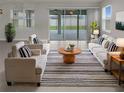 Bright living room with neutral walls, minimalist decor, and sliding glass doors to the patio at 9793 Rally Spring Loop, Wesley Chapel, FL 33545