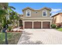 Beautiful home with a three-car garage, a paver driveway, and meticulously maintained landscaping at 5802 Hatteras Palm Way, Tampa, FL 33615