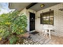 Charming front porch with decorative brick, seating, and a well-manicured garden at 12205 Kelly Ln, Thonotosassa, FL 33592