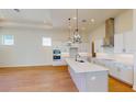 Bright modern kitchen boasts white cabinets, an island with a sink, and stainless steel appliances at 3603 Lajuana Blvd, Wesley Chapel, FL 33543