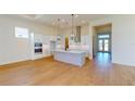 Open concept kitchen features a large island, white cabinetry, stainless steel appliances, and light hardwood floors at 3603 Lajuana Blvd, Wesley Chapel, FL 33543