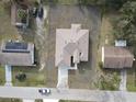 An aerial view of a one-story home with a large roof in a neighborhood with lush trees at 383 Yeager St, Port Charlotte, FL 33954