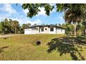 Spacious single-Gathering home with a two-car garage, surrounded by mature trees and lush greenery at 82 Venango St, Port Charlotte, FL 33954