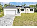 Charming single-Gathering home featuring a two-car garage, manicured lawn, and stylish exterior finishes at 82 Venango St, Port Charlotte, FL 33954