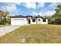 Elegant single-Gathering home with a two-car garage, and a well-maintained front yard on a sunny day at 82 Venango St, Port Charlotte, FL 33954