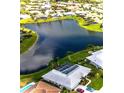 Aerial view of a beautiful lakefront home with a screened-in pool and meticulously landscaped backyard at 1727 Waxwing Cir, Venice, FL 34293