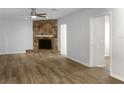 Spacious living room with a stone fireplace, wood-look flooring, and neutral paint at 3305 Acapulco Dr, Riverview, FL 33578