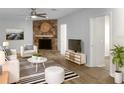 Bright living room featuring modern furnishings, a stone fireplace, and laminate floors at 3305 Acapulco Dr, Riverview, FL 33578