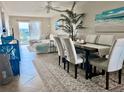 Bright living room and dining area with beach themed artwork, tile floors, and neutral tones at 3672 Lake Bayshore Dr # K327, Bradenton, FL 34205