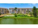 Scenic view of the condo building by the lake, featuring greenery and well-kept grounds at 3672 Lake Bayshore Dr # K327, Bradenton, FL 34205