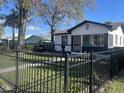 View of the home featuring black fencing, a well-maintained lawn, and black trim at 2032 22Nd S Ave, St Petersburg, FL 33712