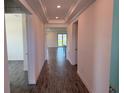 Bright hallway featuring decorative ceilings, recessed lighting and stylish dark flooring at 25164 Calusa Dr, Punta Gorda, FL 33955