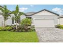 Charming single-story home with a two-car garage, manicured landscaping, and a welcoming paver driveway at 467 Sun Chaser Dr, Nokomis, FL 34275