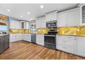 Bright kitchen with white cabinets, stainless steel appliances, and stunning countertops at 1690 Bayshore Dr, Englewood, FL 34223