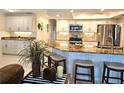 Bright kitchen featuring white cabinets, a granite countertop island, and stainless steel appliances at 1706 S Lakeside Ct, Venice, FL 34293