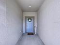 Covered entryway featuring a wreath on the front door and welcome sign at 36495 Garden Wall Way, Zephyrhills, FL 33541