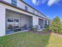 View of a beautiful screened porch with outdoor seating overlooking the manicured lawn and lush landscaping at 36495 Garden Wall Way, Zephyrhills, FL 33541