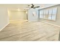 A spacious living room featuring sleek wood-look floors and a large window with shutter style blinds at 5521 80Th Street North # 306, St Petersburg, FL 33709