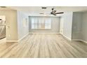 An open-concept living room with wood-look flooring, a ceiling fan, and a pass-through to the kitchen at 5521 80Th Street North # 306, St Petersburg, FL 33709