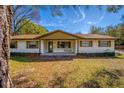 Inviting single-story home showcasing a covered front porch with a swing and well-maintained front yard at 32589 Greenwood Loop, Wesley Chapel, FL 33545