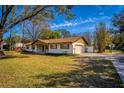 Inviting single-story home showcasing a covered front porch with a swing and well-maintained front yard at 32589 Greenwood Loop, Wesley Chapel, FL 33545