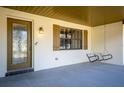 Covered front porch with a decorative door, window with shutters, and a charming swing for relaxing at 32589 Greenwood Loop, Wesley Chapel, FL 33545