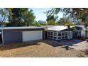 Exterior shot of house with white garage door, mature trees and appealing curb appeal at 10952 61St Ave, Seminole, FL 33772