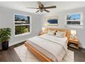 A cozy main bedroom with a ceiling fan, hardwood floors, two windows and a bright white rug at 523 Red Mangrove Ln, Apollo Beach, FL 33572