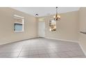 Inviting living area with tile flooring, chandelier, and natural light from two large windows at 15121 Searobbin Dr, Lakewood Ranch, FL 34202