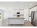 Bright kitchen featuring a granite island, stainless steel appliances, and ample cabinet space at 31610 Malbec Dr, Brooksville, FL 34602