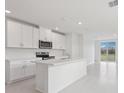 Bright kitchen features white cabinets, an island with sink and stainless steel appliances at 3634 Moscato Dr, Brooksville, FL 34602