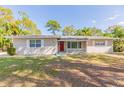 Inviting single-story home with a classic design, featuring a red front door and mature landscaping at 777 27Th S Ave, St Petersburg, FL 33705