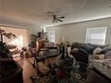 Cozy living room featuring hardwood floors, a ceiling fan, and natural lighting at 3101 Clovewood Pl, Seffner, FL 33584