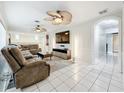 Spacious living room with white tile floor, fan and sectional couch; great for relaxation at 8135 33Rd Ave N, St Petersburg, FL 33710